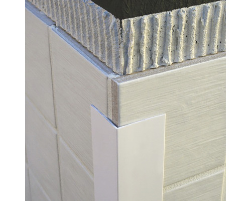Prim-plan al unui colț cu plăci ceramice și un profil de colț ceramic alb.