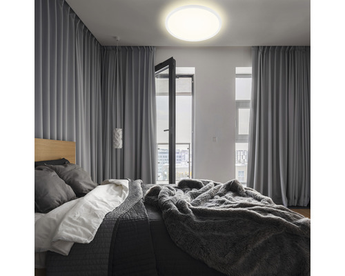 Dormitor cu pat, perdele și plafonieră rotundă