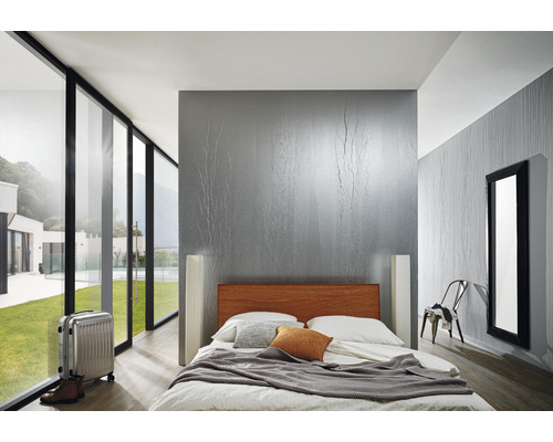 Dormitor luminos cu pat, valiză și fereastră mare cu vedere la verdeață