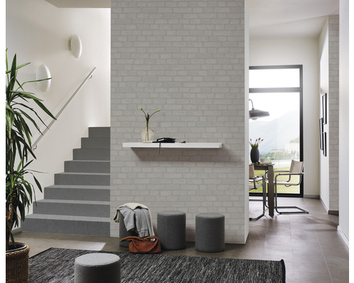 Hol luminos cu tapet cu aspect de cărămidă, scară, masă și scaune.