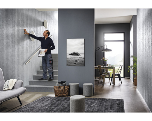 Scenă cu o scară cu design modern, cu o persoană care atinge un perete, mobilier și decorațiuni