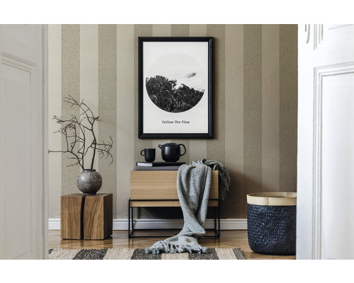 Cameră de zi cu tapet în dungi, comodă din lemn, decorațiuni și coș împletit