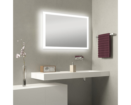 Baie modernă cu oglindă iluminată, chiuvetă, robinet și suport pentru prosoape.