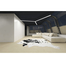 Cameră de zi modernă cu tavan negru, canapea de colț, covor din piele de vacă și plafonieră liniară