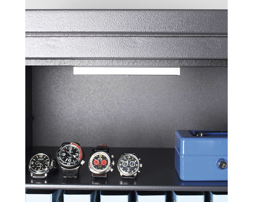 Interiorul unui seif cu ceasuri și o casetă de bani