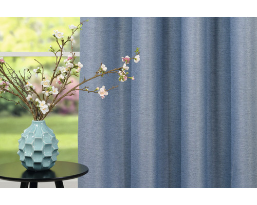 Material decorativ lângă o vază cu ramuri înflorite