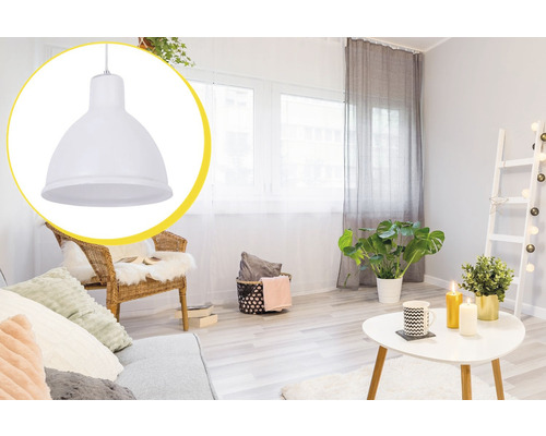 Cameră de zi cu lampă suspendată, canapea, fotoliu, masă și plante de interior pentru o atmosferă luminoasă și prietenoasă.