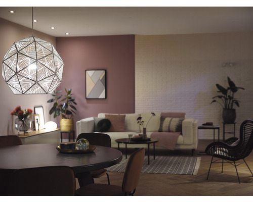 Cameră de zi cu masă de sufragerie, canapea și lampă suspendată geometrică