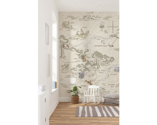 Cameră de copii cu harta Winnie the Pooh ca tapet de perete, podea din lemn și balansoar alb.