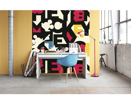 O cameră cu un birou, un scaun și tapet cu un model de litere