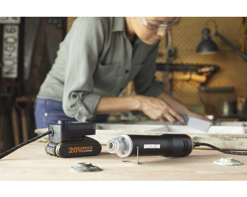 Pistol cu aer cald pe acumulator WORX cu acumulator și femeie cu ochelari de protecție la lucru