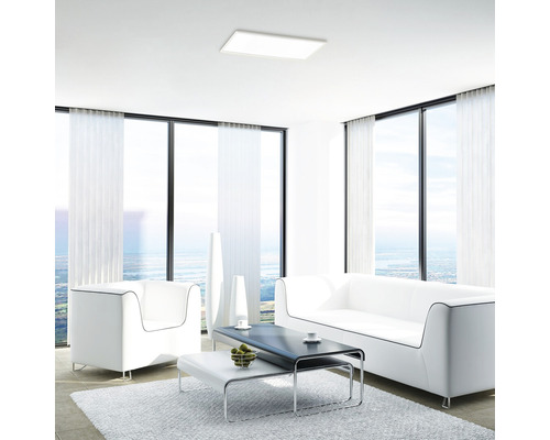 Living luminos cu plafonieră, canapea și fotolii.