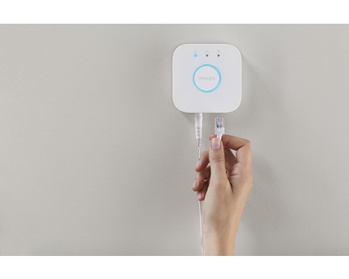 Philips Hue Bridge cu cablu de rețea în mână