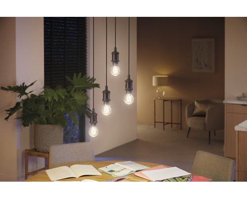 Patru becuri suspendate deasupra unei mese de sufragerie într-o cameră