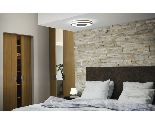 Dormitor cu pat dublu, uși glisante din lemn, perete de piatră și plafonieră