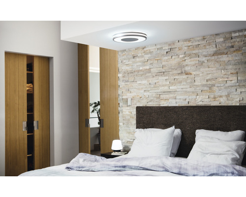 Dormitor cu plafonieră, perete de piatră, pat și uși glisante