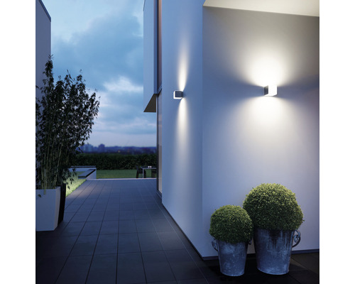 Fațadă modernă de casă cu două aplice de perete pătrate care emit lumină caldă