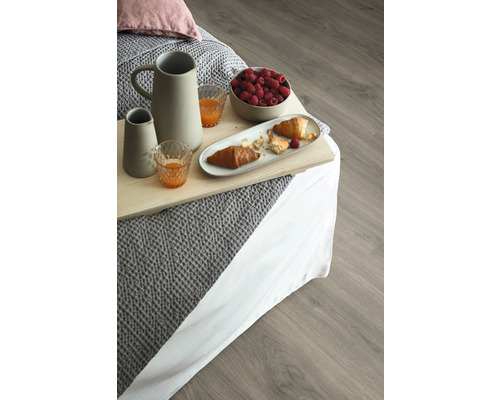 Imagine cu mic dejun în pat cu băuturi, croissante și zmeură pe o podea de lemn