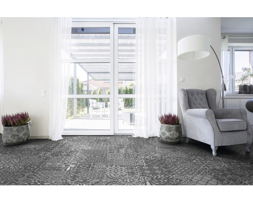 Living cu podea de vinil cu model, fotoliu și plante în ghiveci în fața unei uși de terasă