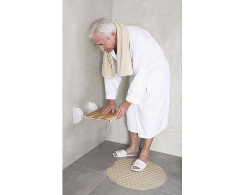 Bărbat în baie cu scaun de duș și covoraș de baie