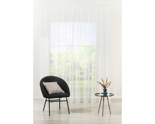 Interior cu perdea albă, fotoliu și măsuță laterală