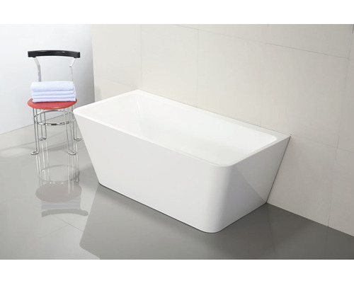 Cadă de baie freestanding lângă un scaun cu prosoape în baie.