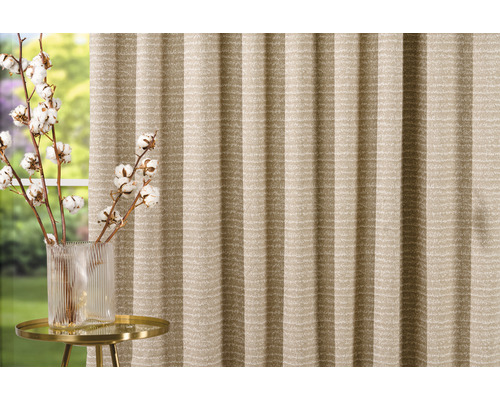 Pliseu decorativ în fața unei ferestre cu ramuri de bumbac într-o vază pe o măsuță laterală