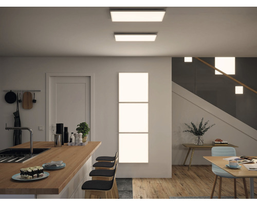 Bucătărie luminoasă, modernă, cu plafoniere LED și panouri de perete care creează o atmosferă prietenoasă.