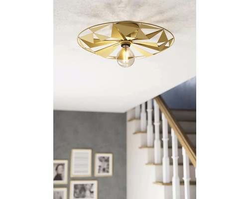 Lumină de plafon aurie cu design geometric și bec într-o sufragerie.