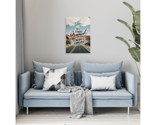 Tablou decorativ cu motiv stradal deasupra unei canapele într-un living.