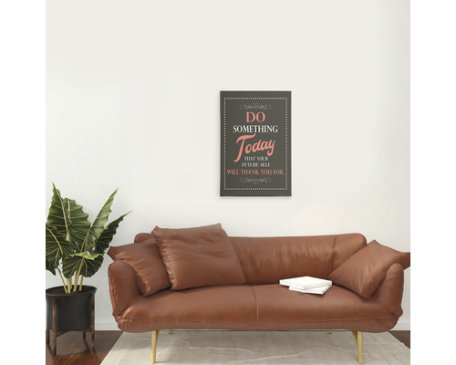 Living cu canapea din piele maro, plantă de interior și tablou de perete