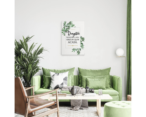 Imagine decorativă de perete cu frunze și textul Dragostea deasupra unei canapele într-o sufragerie.