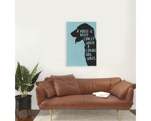 Pictură decorativă de perete cu siluetă de câine și citat deasupra unei canapele maro.