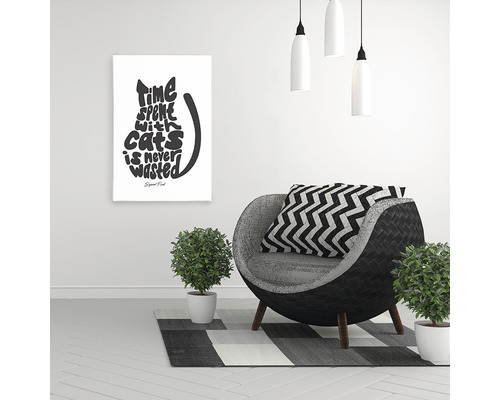 Decor de sufragerie cu fotoliu, plante de apartament și un poster cu un citat despre pisici.