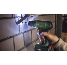 Mașină de găurit care găurește un perete de cărămidă