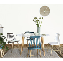 Masa de sufragerie cu scaune, veselă și vază cu flori într-o cameră luminoasă