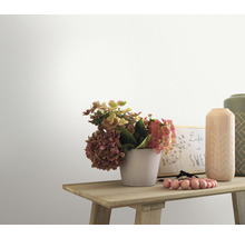 Prim-plan al unei mese de lemn decorate cu flori, vaze și o ramă foto în fața unui perete alb