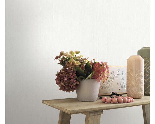 Prim-plan al unei mese de lemn decorate cu flori, vaze și o ramă foto în fața unui perete alb