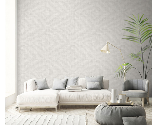 Living cu tapetă textilă bej, canapea, fotoliu și lampă de podea