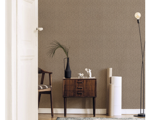 Cameră de zi cu tapet modelat, comodă, scaun, lampă de podea și decorațiuni.