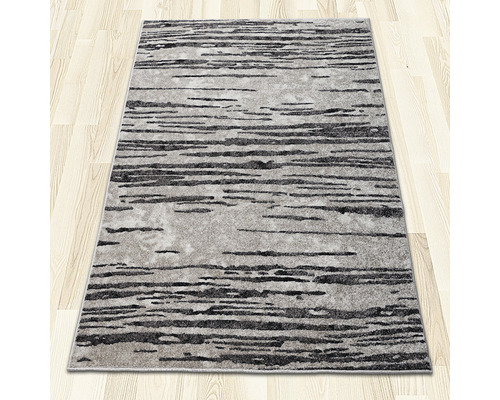 Covor cu model abstract pe podea de lemn