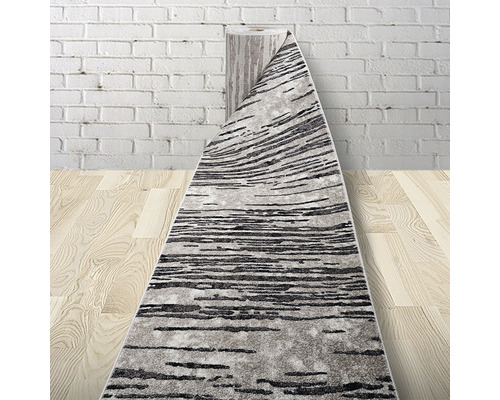 Covor gri-negru desfășurat pe podea de lemn