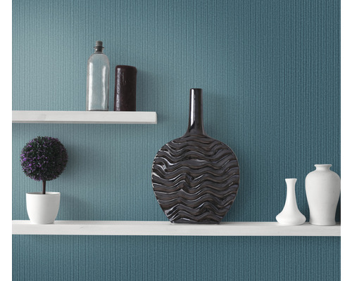 Rafturi decorative cu vaze, o plantă și o sticlă în fața unui perete