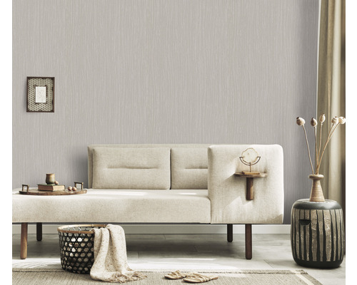 Living cu tapet vlies gri deschis cu model liniar, canapea și obiecte decorative pentru o atmosferă confortabilă.