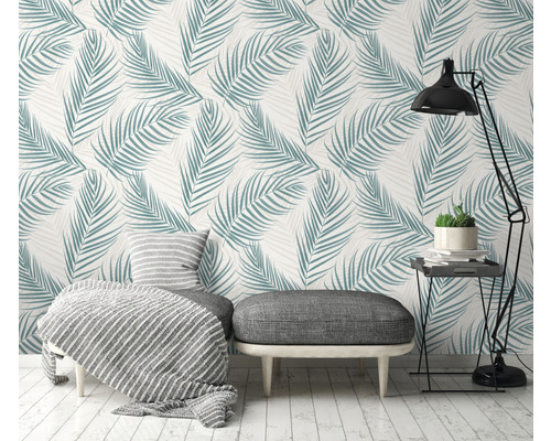 Cameră de zi cu tapet cu frunze de palmier, taburet, lampă și măsuță laterală pentru o ambianță luminoasă