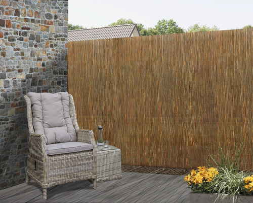 Scenă de terasă cu mobilier din ratan și rogojină de stuf ca paravan de confidențialitate