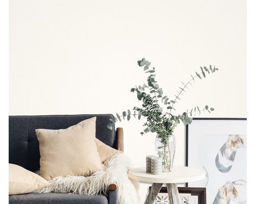 Cameră de zi cu canapea gri, perne, măsuță laterală, vază cu eucalipt și rame foto.