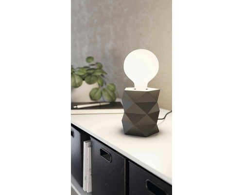 Lampă de masă decorativă cu design geometric pe o masă