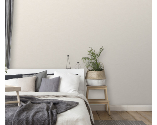 Dormitor cu pat, perne, pătură, plantă la ghiveci și noptieră