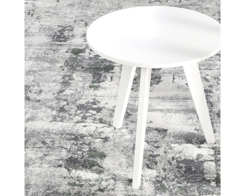 Măsuță laterală rotundă albă pe un covor cu model